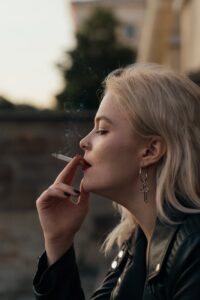 woman in black jacket smoking cigarette